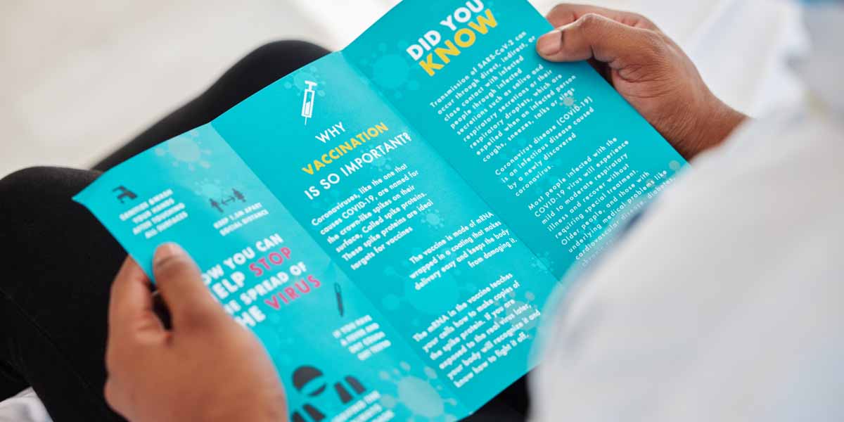 An over the shoulder view of a person holding a tri-fold brochure.